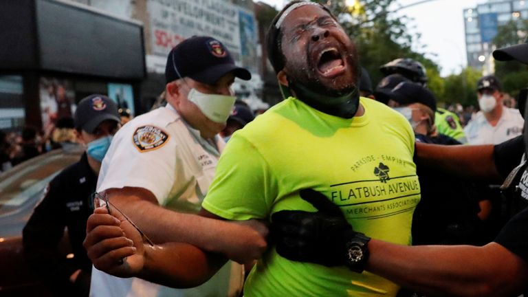 Police officers detain a man during an &#34;I can&#39;t breathe&#34; vigil and rally in the Brooklyn borough of New York, NY, U.S., following the death of African-American George Floyd who was seen in graphic video footage gasping for breath as a white officer knelt on his neck in Minneapolis