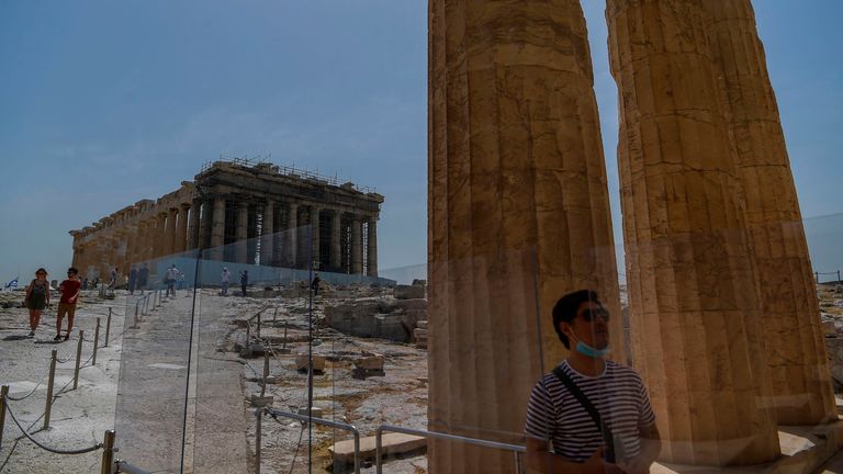 A tourist visits the Parthenon temple on the archeological site of the Acropolis in Athens, Greece