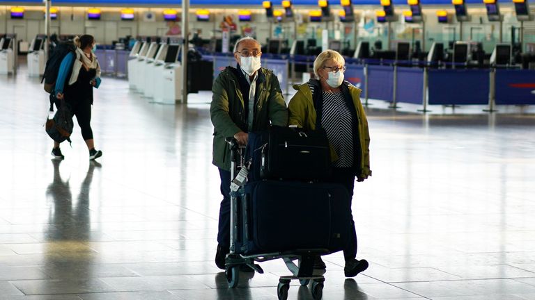 People in masks are seen at Heathrow Airport