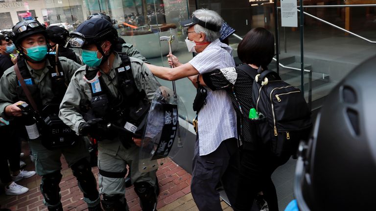 An anti-government demonstrator argues with riot police