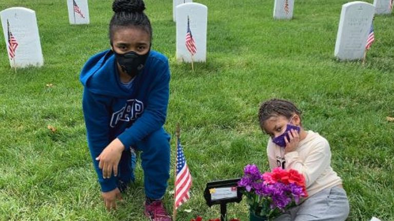 Leilani’s younger sisters at her grave in Arlington National Cemetery