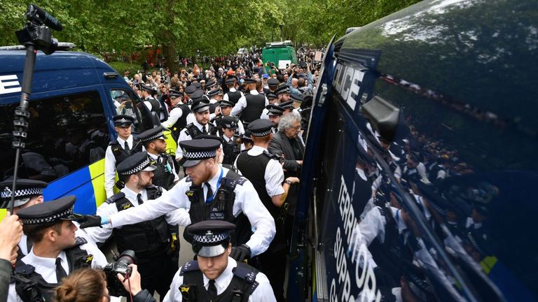 Piers Corbyn (C - grey top), brother of former Labour Party leader Jeremy Corbyn, is led away by police officers into a police van at an anti-coronavirus lockdown demonstration in Hyde Park in London on May 16, 2020, following an easing of lockdown rules in England during the novel coronavirus COVID-19 pandemic. - Fliers advertising 'mass gatherings' organised by the UK Freedom Movement to oppose the government lockdown measures and guidelines put in place to halt the spread of coronavirus in pa
