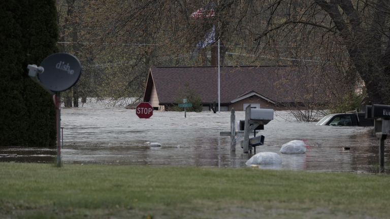 Vehicles and signs are submerged in downtown Sanford, Michigan, after a nearby dam burst