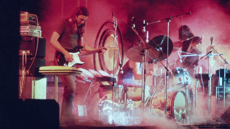 Pink Floyd playing on the stage surrounded with a smoke and illuminated with a red stage lights during the concert at Merriweather Post Pavilion, Columbia, Maryland in June 1973, July, 1973. Image courtesy National Archives. (Photo by Smith Collection/Gado/Getty Images)