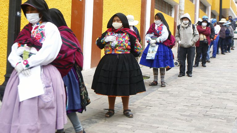 People queue outside a bank in Puno to collect government aid during the crisis in Peru