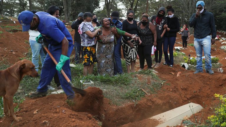 Relatives react during the burial of 64-year-old Raimunda Conceicao Souza, who died from COVID-19, at Vila Formosa cemetery, Sao Paulo