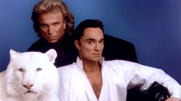 Siegfried (L) & Roy pose with a white tiger in this undated photo