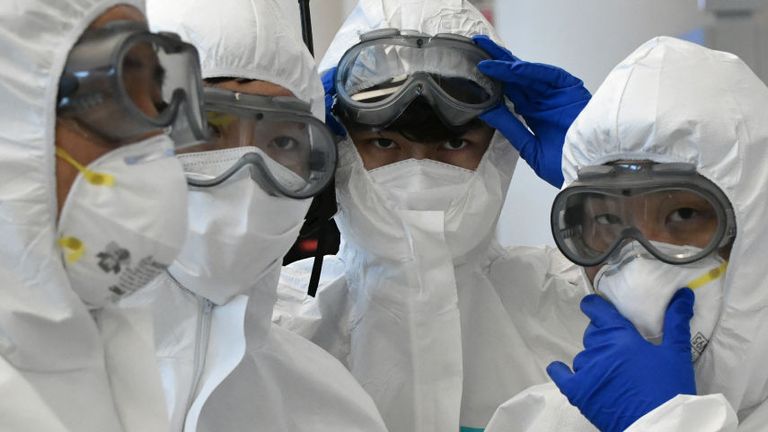 TOPSHOT - Police officers wearing protective clothing wait to guide South Korean citizens repatriated from Italy to a bus at Incheon international airport, west of Seoul, on April 1, 2020. - The first charter flight arranged by South Korean government to evacuate its citizens from coronavirus-hit Italy returned home with 309 citizens on April 1, amid the worsening virus outbreak in the European country. (Photo by Jung Yeon-je / AFP) (Photo by JUNG YEON-JE/AFP via Getty Images)
