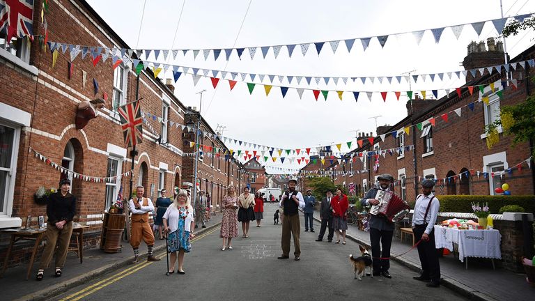 Residents of Cambrian Road dressed up in period costume maintain social distancing guidelines as they pose on their street to mark the 75th anniversary of VE Day in Chester, northwest England on May 8, 2020. (Photo by PAUL ELLIS / AFP) (Photo by PAUL ELLIS/AFP via Getty Images)