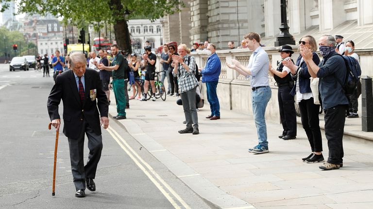 A veteran is applauded at The Cenotaph in Westminster during a two minute silence on the 75th Anniversary of VE Day in London, Britain, May 8, 2020. REUTERS/John Sibley