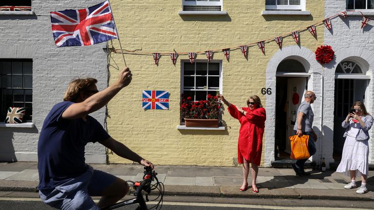 A man waves a Union flag on his bike on a street in Parsons Green, London 