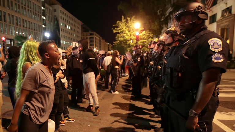 A woman yells to police officers in Washington