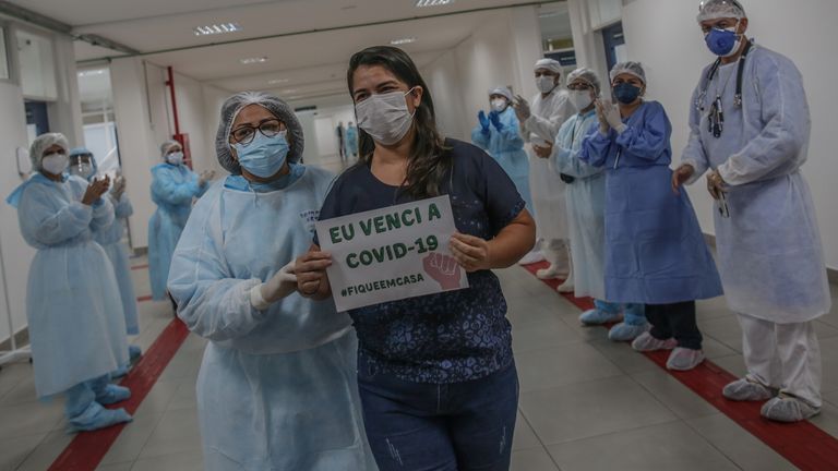 A patient holds a sign that reads &#39;I beat the COVID-19 #StayAtHome&#39; at a hospital in Manaus, Brazil