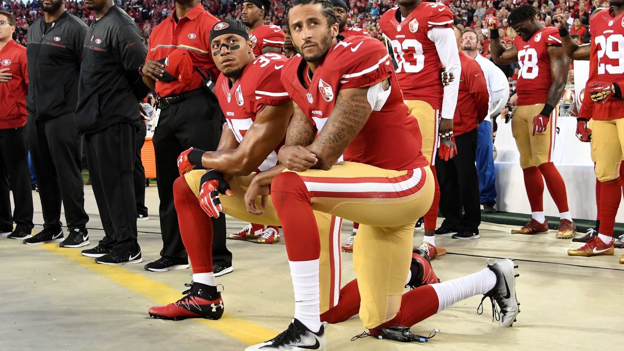 Colin Kaepernick (R) and Eric Reid of the San Francisco 49ers kneel in prot...