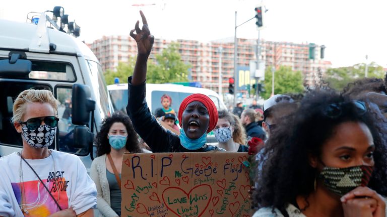 A woman holding a placard for George Floyd in front of the US Embassy at a protest in Berlin, on May 30, 2020. - Violent protests erupted across the United States late on May 29 over the death of a handcuffed black man in police custody, with murder charges laid against the arresting Minneapolis officer failing to quell seething anger. (Photo by Odd ANDERSEN / AFP) (Photo by ODD ANDERSEN/AFP via Getty Images)