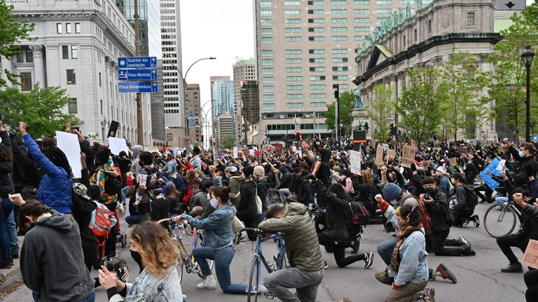 The crowd kneel as it observes a minute of silence in memory of George Floyd, killed at the hands of Minnieapolis Police, during a rally on Montreal's Place du Canada on May 31, 2020. - Several thousands demonstrators marched on Sunday in central Montreal against racism and police violence, in solidarity with demonstrations in the United States following the death of George Floyd. (Photo by Eric THOMAS / AFP) (Photo by ERIC THOMAS/AFP via Getty Images)