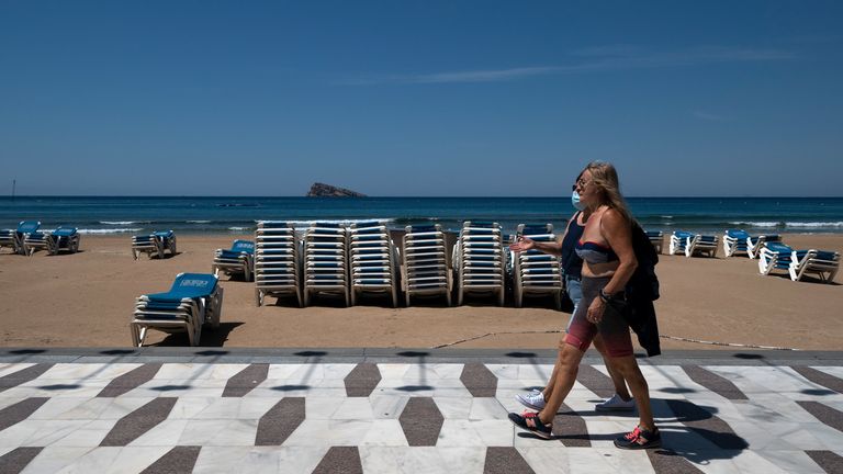 Two women walk along the boardwalk of the closed Levante Beach in Benidorm on June 1, 2020. - With the numbers of new cases and deaths slowing, Spain has begun a gradual, staged transition out of a national lockdown put in place to fight the spread of the novel coronavirus. (Photo by JOSE JORDAN / STR / AFP) (Photo by JOSE JORDAN/STR/AFP via Getty Images)