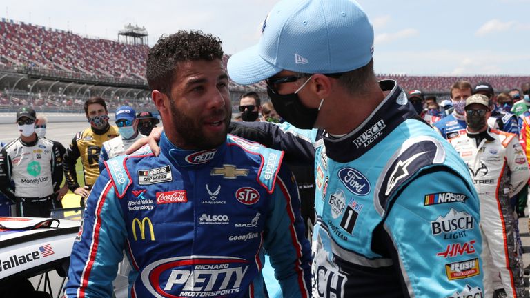 TALLADEGA, ALABAMA - JUNE 22: Bubba Wallace, driver of the #43 Victory Junction Chevrolet, is greeted by Kevin Harvick, driver of the #4 Busch Light Ford, after NASCAR drivers pushed Wallace to the front of the grid as a sign of solidarity with the driver prior to the NASCAR Cup Series GEICO 500 at Talladega Superspeedway on June 22, 2020 in Talladega, Alabama. A noose was found in the garage stall of NASCAR driver Bubba Wallace at Talladega Superspeedway a week after the organization banned the Confederate flag at its facilities. (Photo by Chris Graythen/Getty Images)