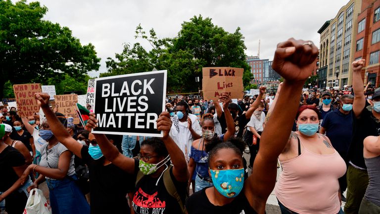 Protesters hold signs as they gather to protest police brutality and racism in the US, with the recent deaths of George Floyd, Ahmaud Arbery, Breonna Taylor, in Boston, Massachusetts, on May 29, 2020. - The Minneapolis police officer accused of killing George Floyd, a handcuffed African American man, was charged with murder on May 29 as authorities declared a curfew after three nights of violent protests left parts of the city in flames. (Photo by Joseph Prezioso / AFP) (Photo by JOSEPH PREZIOSO/AFP via Getty Images)