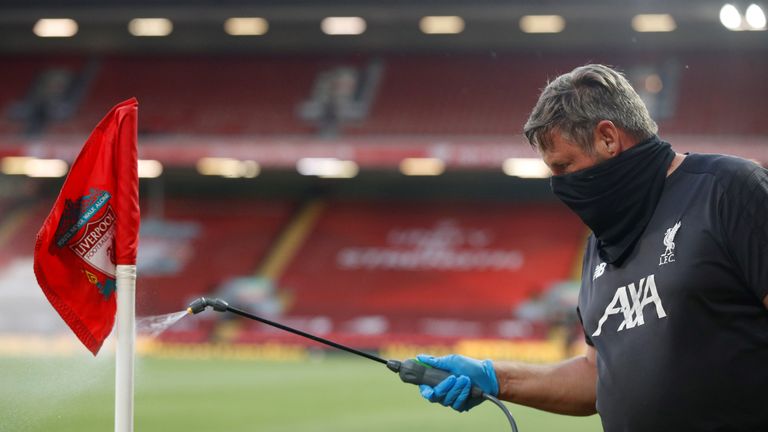 Groundstaff disinfect a corner flag during the English Premier League football match between Liverpool and Crystal Palace at Anfield in Liverpool, north west England on June 24, 2020. (Photo by PHIL NOBLE / POOL / AFP) / RESTRICTED TO EDITORIAL USE. No use with unauthorized audio, video, data, fixture lists, club/league logos or 'live' services. Online in-match use limited to 120 images. An additional 40 images may be used in extra time. No video emulation. Social media in-match use limited to 120 images. An additional 40 images may be used in extra time. No use in betting publications, games or single club/league/player publications. /  (Photo by PHIL NOBLE/POOL/AFP via Getty Images)