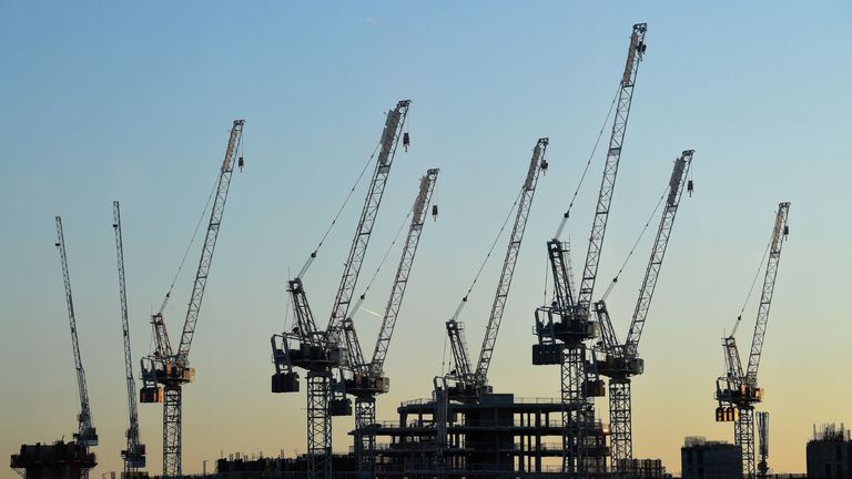 The sun sets beyond construction cranes standing over the building site for new apartments and a retail complex, at the Battersea Power Station redevelopment site in south London on May 14, 2020 following an easing of the novel coronavirus COVID-19 lockdown guidelines. - Prime Minister Boris Johnson has urged people to continue to work at home if they can but said those in sectors such as manufacturing and construction could return if it is safe. (Photo by JUSTIN TALLIS / AFP) (Photo by JUSTIN TALLIS/AFP via Getty Images)