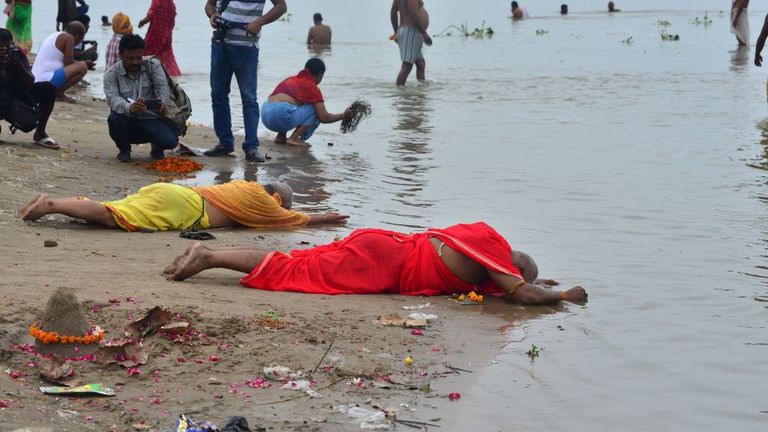 Hindu devotees pray to the Sun God at the Sangam, the confluence of the Rivers Ganges, Yamuna and mythical Saraswati, during an annular solar eclipse in Allahabad on June 21, 2020. (Photo by SANJAY KANOJIA / AFP) (Photo by SANJAY KANOJIA/AFP via Getty Images)
