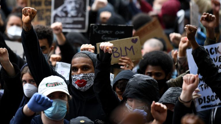 Demonstranten halten Transparente hoch, als sie am 6. Juni 2020 an einer Demonstration auf dem Parliament Square im Zentrum von London teilnehmen, um ihre Solidarität mit der Black Lives Matter-Bewegung nach der Ermordung von George Floyd, einem unbewaffneten schwarzen Mann, der nach einer Polizei starb, auszudrücken Offizier kniete nieder.  An seinem Hals in Minneapolis.  - Kniende und singende, ignorierende soziale Distanzierungsmaßnahmen, wütende Demonstranten von Sydney nach London begannen am Samstag ein Wochenende der Weltmärsche gegen Rassismus und Polizeibrutalität.  (Foto 