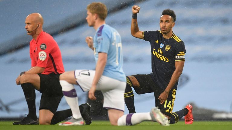 Arsenal&#39;s Pierre-Emerick Aubameyang gestures as he takes a knee with Manchester City&#39;s Kevin De Bruyne and referee Anthony Taylor before the match as play resumes behind closed doors following the outbreak of the coronavirus disease
