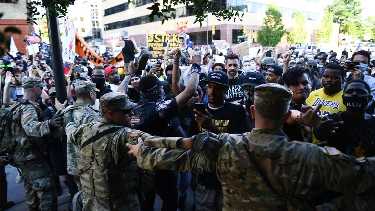 National Guards form a line in front of "Black Lives Matter" protestors while Trump supporters scream from across the line in Tulsa, Oklahoma where Donald Trump holds a campaign rally at the BOK Center on June 20, 2020