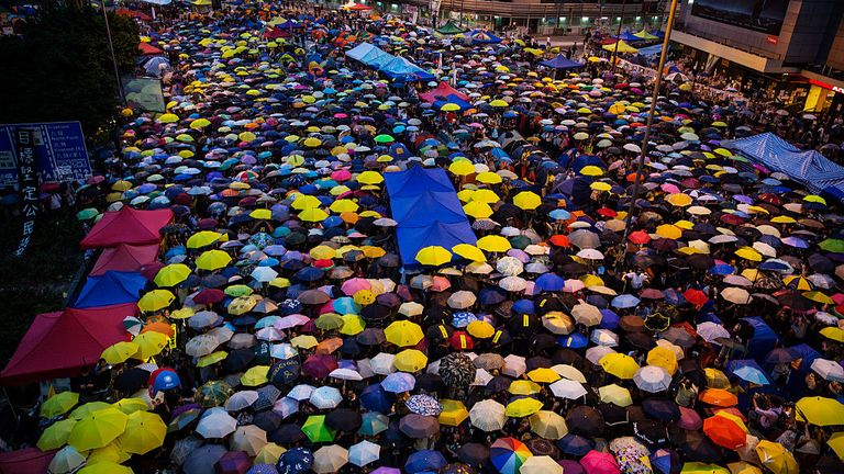 HONG KONG - OCTOBER 28: Umbrellas are opened as tens of thousands come to the main protest site one month after the Hong Kong police used tear gas to disperse protesters October 28, 2014 in Hong Kong, Hong Kong. A peaceful safe atmosphere remains at the massive protest site as artists freely express themselves and families bring their children to experience the Umbrella Revolution. (Photo by Paula Bronstein/Getty Images)
