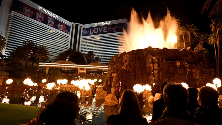 LAS VEGAS, NEVADA - MARCH 14: Building wraps for the “The Beatles LOVE by Cirque du Soleil” show are shown on the exterior of The Mirage Hotel & Casino as visitors watch the resort&#39;s volcano attraction as the coronavirus continues to spread across the United States