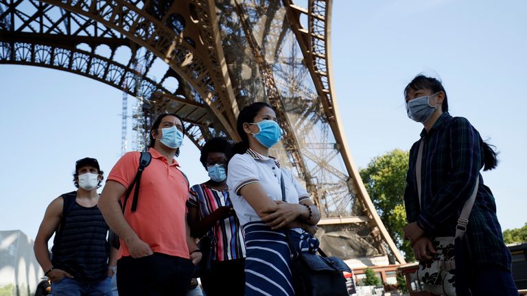 Visitors wearing protective facemasks queue as they wait for the partial reopening of Eiffel Tower on June 25, 2020, in Paris, as France eases lockdown measures taken to curb the spread of the COVID-19 caused by the novel coronavirus. - Tourists and Parisians will again be able to admire the view of the French capital from the Eiffel Tower after a three-month closure due to the coronavirus -- but only if they take the stairs. (Photo by Thomas SAMSON / AFP) (Photo by THOMAS SAMSON/AFP via Getty I
