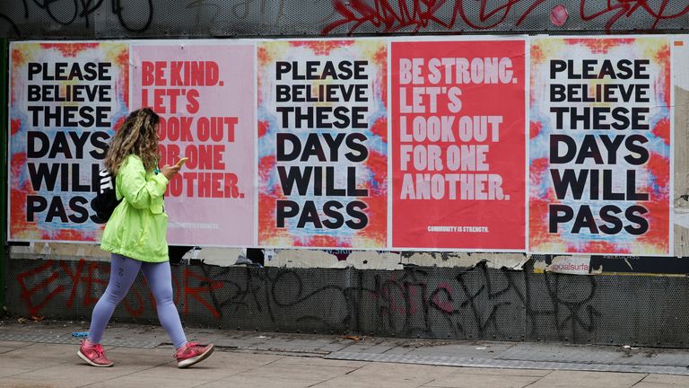 A woman walks by banners in Manchester