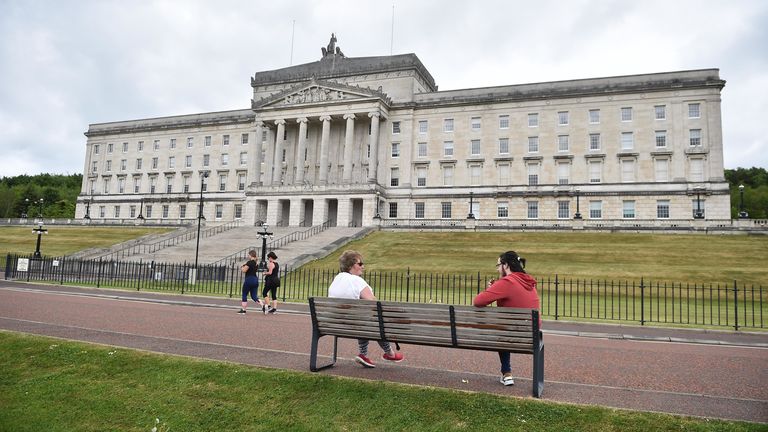 Friends observe social distancing as they meet outside Stormont in Belfast, Northern Ireland