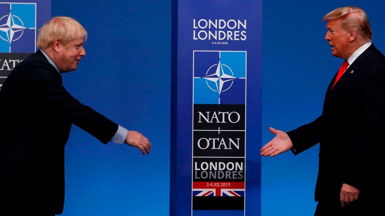 British Prime Minister Boris Johnson (left) greets US President Donald Trump upon his arrival at the NATO summit at the Grove Hotel in Watford, northeast London, on December 4, 2019.