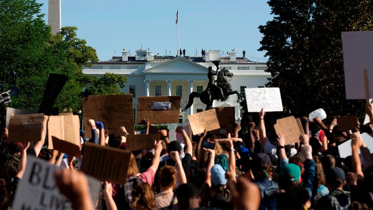 TOPSHOT - Demonstrators hold up placards protest outside of the White House, over the death of George Floyd in Washington D.C. on June 1, 2020