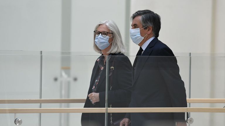 Former France PM Francois Fillon (L) and his wife Penelope Fillon (C) arrive at court