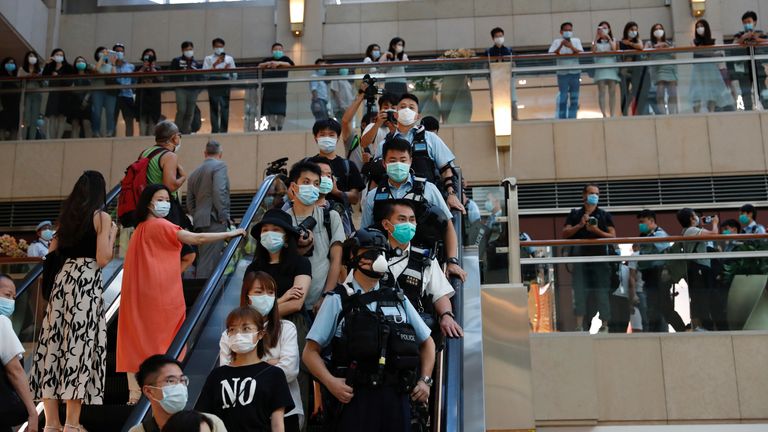 Riot police were deployed to an upmarket shopping centre in Hong Kong as peaceful pro-democracy protesters carried out a minute&#39;s silence