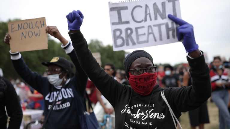 A protester wearing a face mask holds a sign saying &#39;I can&#39;t breathe&#39; 