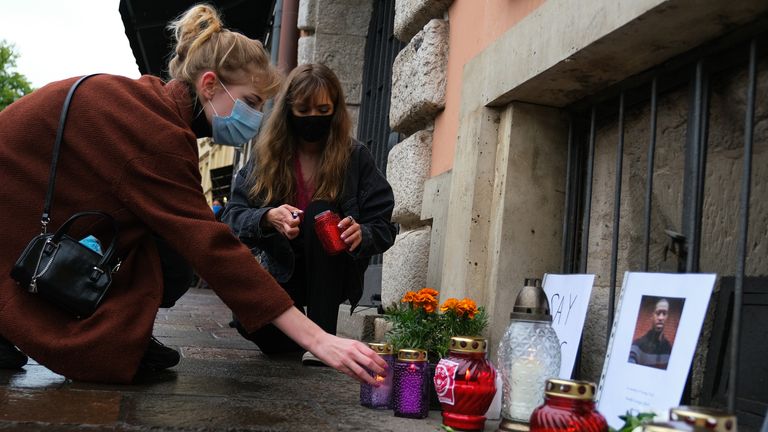 Women wear protective face masks as they light candles to place in a small memorial for George Floyd in front of the US Consulate in Krakow, Poland