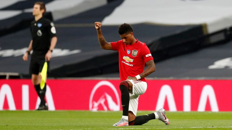 Manchester United&#39;s English striker Marcus Rashford (R) takes a knee