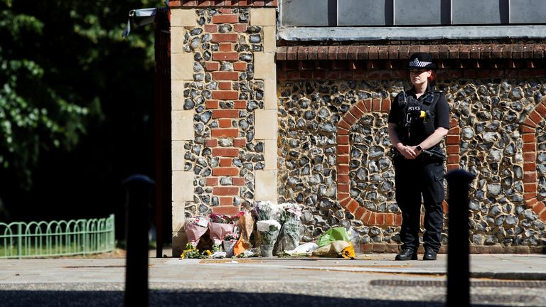 A police officer stands observing minute&#39;s silence near to the scene of reported multiple stabbings in Reading