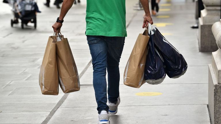 A shopper carries a variety of full shopping bags on Oxford Street in London