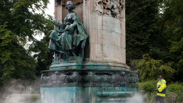 Council workers clean graffiti from a statue of Queen Victoria in Woodhouse Moor, Leeds