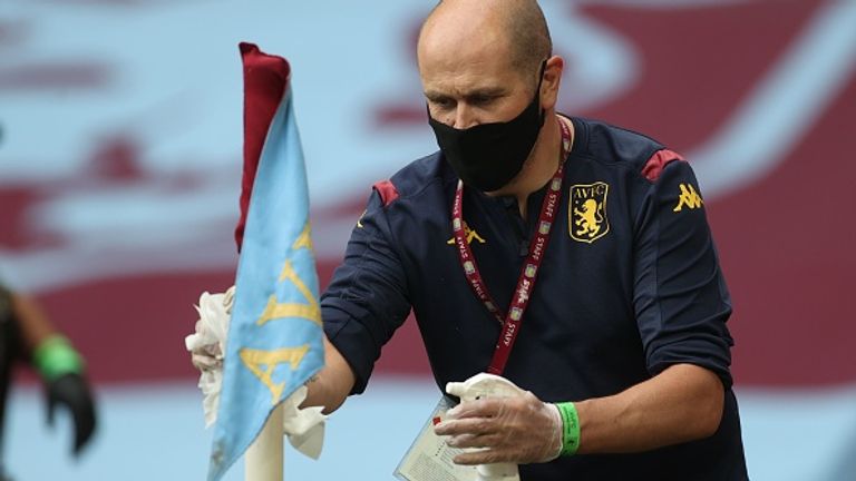 A staff member disinfects a corner flag as part of measures to protect against coronavirus