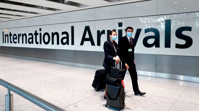 British Airways flight crew wear face masks as they arrive at Terminal 5 at London Heathrow