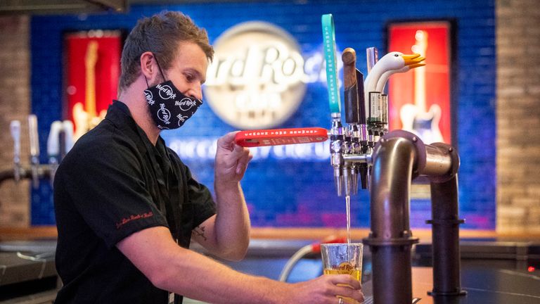 A bartender wears PPE as he pulls a pint behind the bar of the Hard Rock Cafe&#39;s European flagship restaurant in Piccadilly Circus, London, as it prepares to reopen to members of the public when the lifting of further lockdown restrictions in England comes into effect on Saturday.