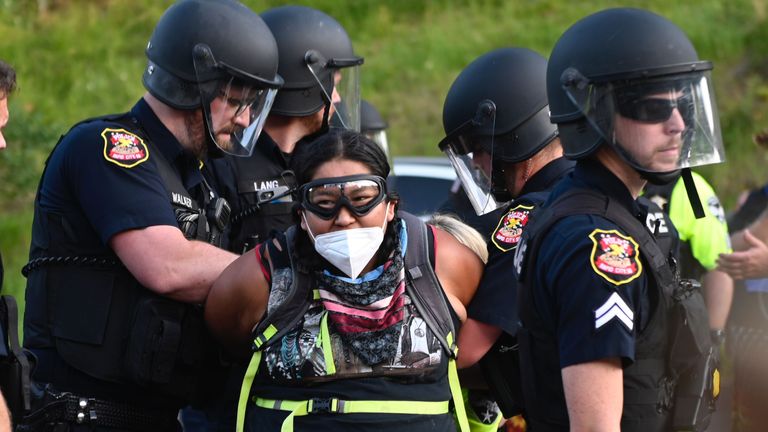 Police arrest a protester wearing a facemask as activists and members of different tribes from the region blocked the road to Mount Rushmore National Monument in Keystone, South Dakota on July 3, 2020, during a demonstration around the Mount Rushmore National Monument and the visit of US President Donald Trump. (Photo by ANDREW CABALLERO-REYNOLDS / AFP) (Photo by ANDREW CABALLERO-REYNOLDS/AFP via Getty Images)