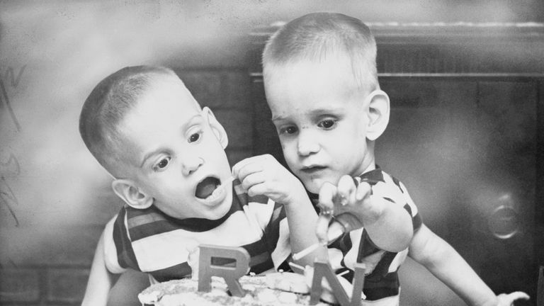 (Original Caption) Ohio's Siamese Twins Celebrate Birthday. Dayton, Ohio: Donnie and Ronnie Galyon, Siamese twins, of Dayton, are shown doing a demolition job on the big cake that featured their second birthday party. The cake was made by their mother, Mrs. Wesley Galyon, but the boys seem to prefer the candle to the icing. The twins now weigh 54 pounds.