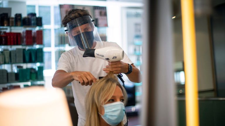 Senior Style Director Nick Peters wears PPE as he cuts a staff member's hair at Daniel Galvin hairdressers, as their flagship salon in Marylebone prepares for reopening as further coronavirus lockdown restrictions are lifted in England.